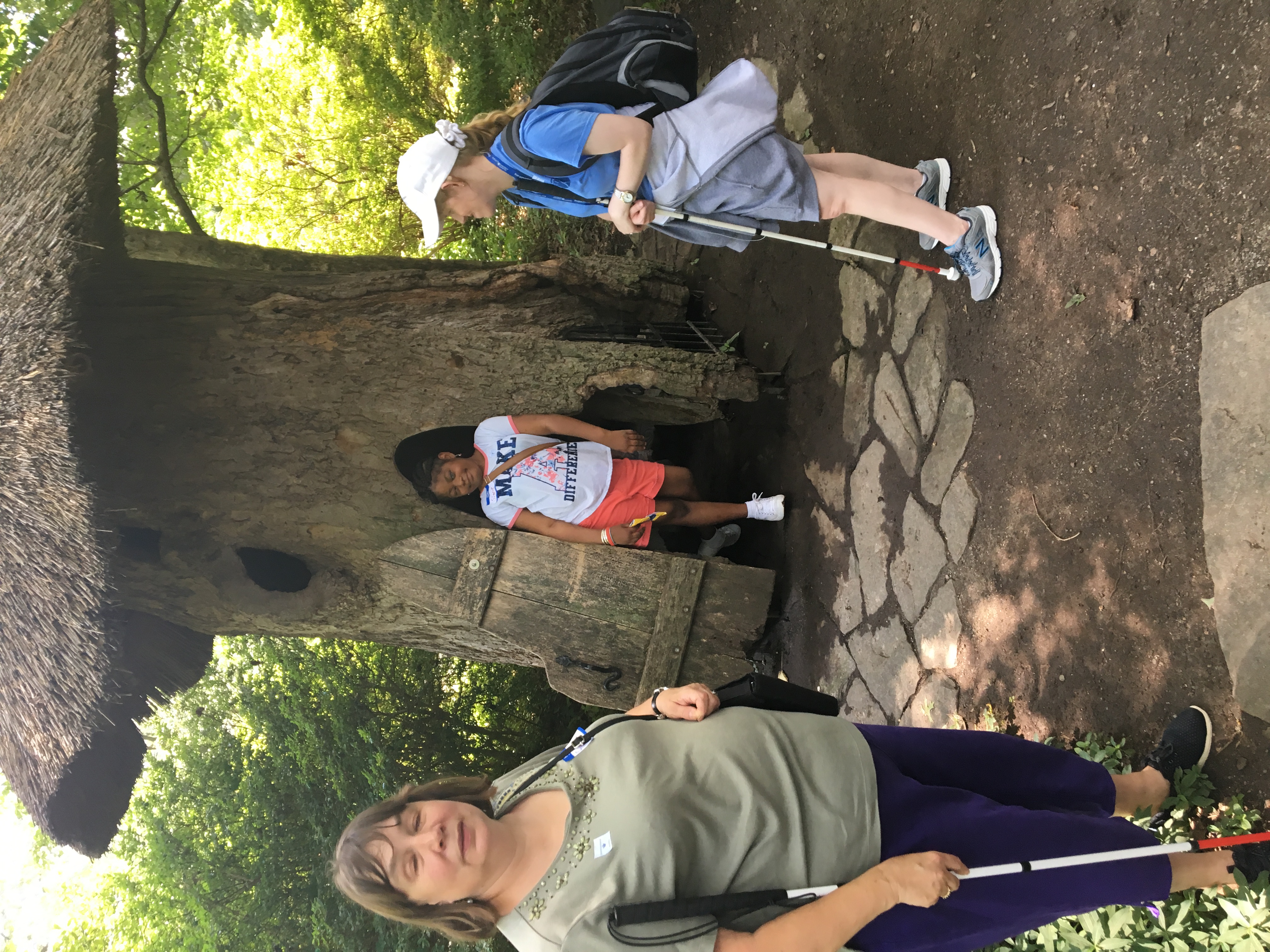 BELL Academy instructors standing outside the fairy acorn hut with one of their students.